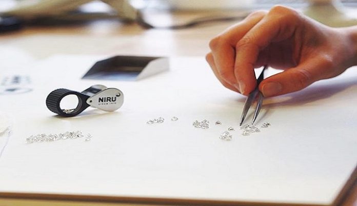 A worker inspects diamonds at Niru