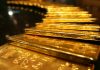 Gold eases from 1-week high as dollar nudges up