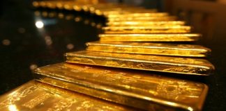 Gold eases from 1-week high as dollar nudges up