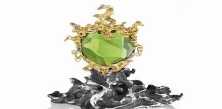 Green Genie Pendant by Naomi Sarna. 178.5 ct. peridot, with multicolored diamond, sapphire, garnet and amethyst accents, set in 18K yellow gold, on a silver presentation base.