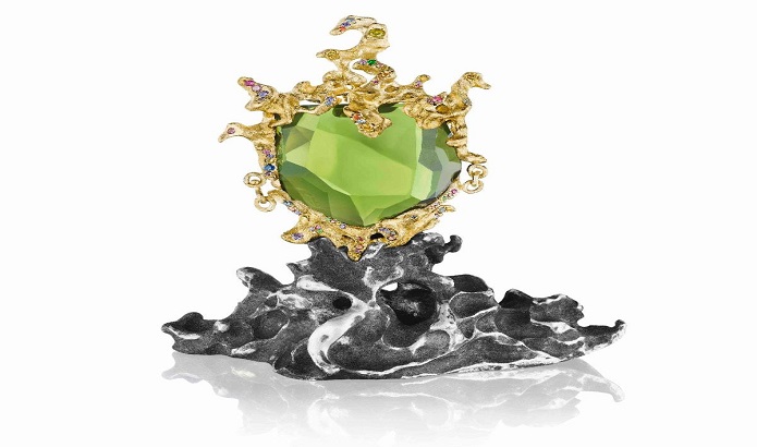 Green Genie Pendant by Naomi Sarna. 178.5 ct. peridot, with multicolored diamond, sapphire, garnet and amethyst accents, set in 18K yellow gold, on a silver presentation base. Green Genie Pendant by Naomi Sarna. 178.5 ct. peridot, with multicolored diamond, sapphire, garnet and amethyst accents, set in 18K yellow gold, on a silver presentation base.
