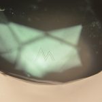 Myne London ‘M’ monogram placed beneath the surface of the crown using the Opsydia Sub-Surface System D5000, photographed at 100x magnification.
